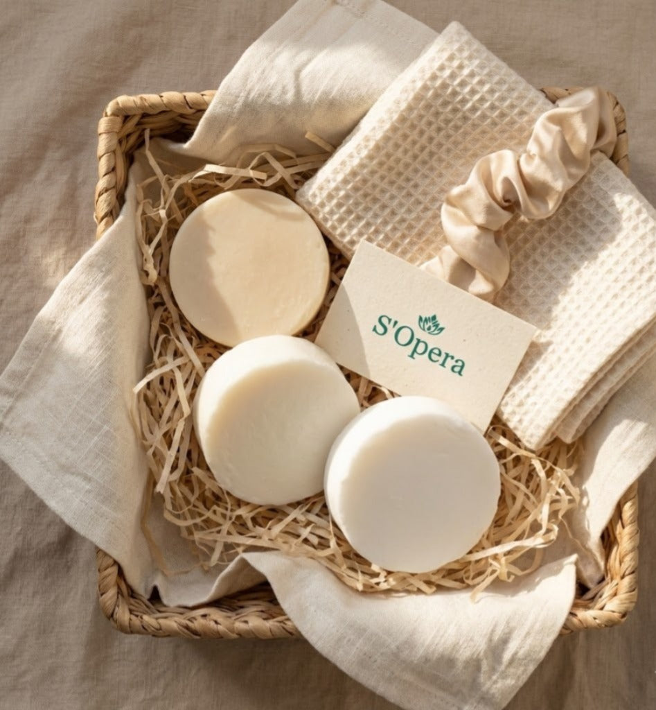 Three bars of soap and a washcloth in a woven basket with 'S'Opera' branding.