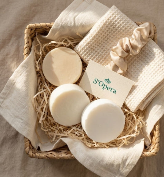 Three bars of soap and a washcloth in a woven basket with 'S'Opera' branding.
